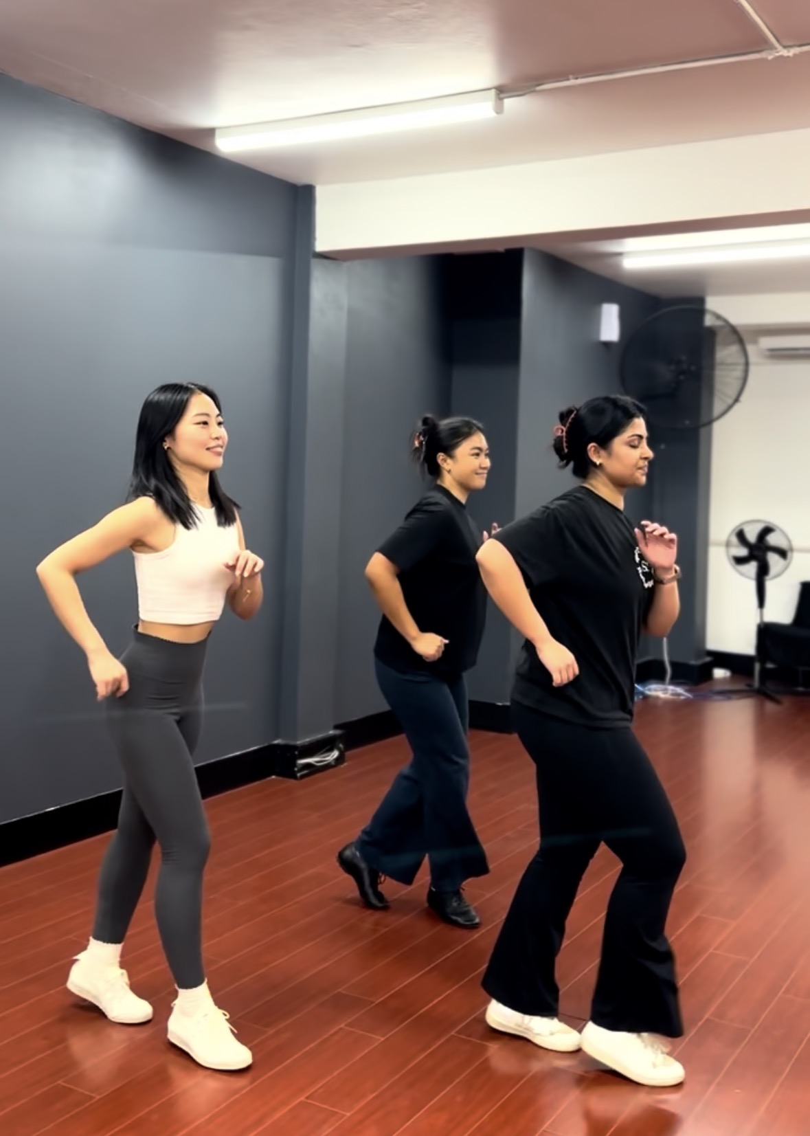 Small group dance class in studio — students mid-step