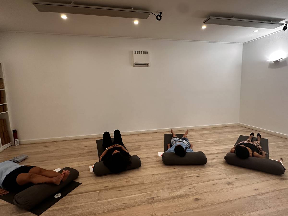 PSICOSOMA session — participants resting on mats with bolsters in studio