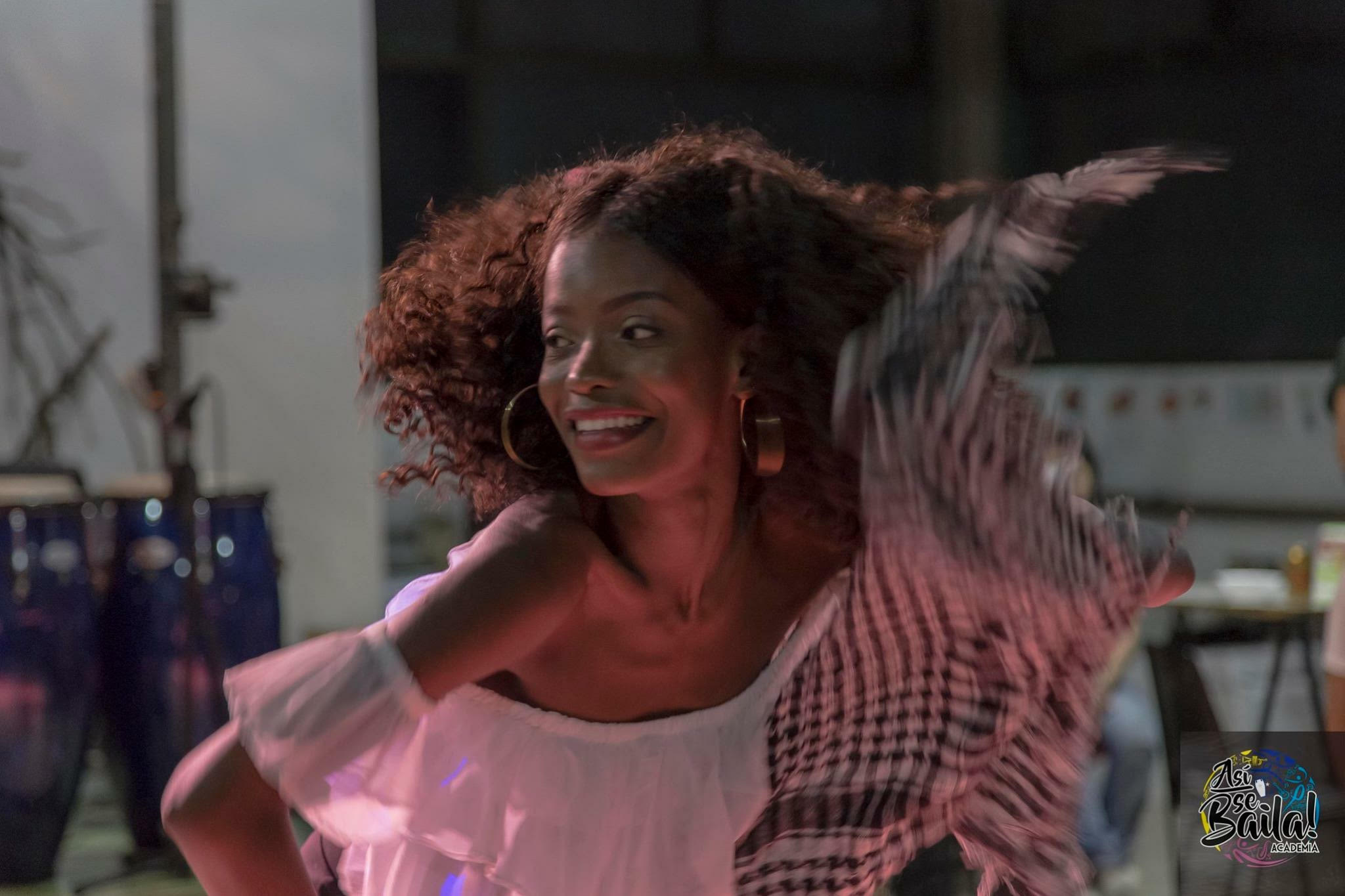 Samara dancing with hair flowing, drums in background