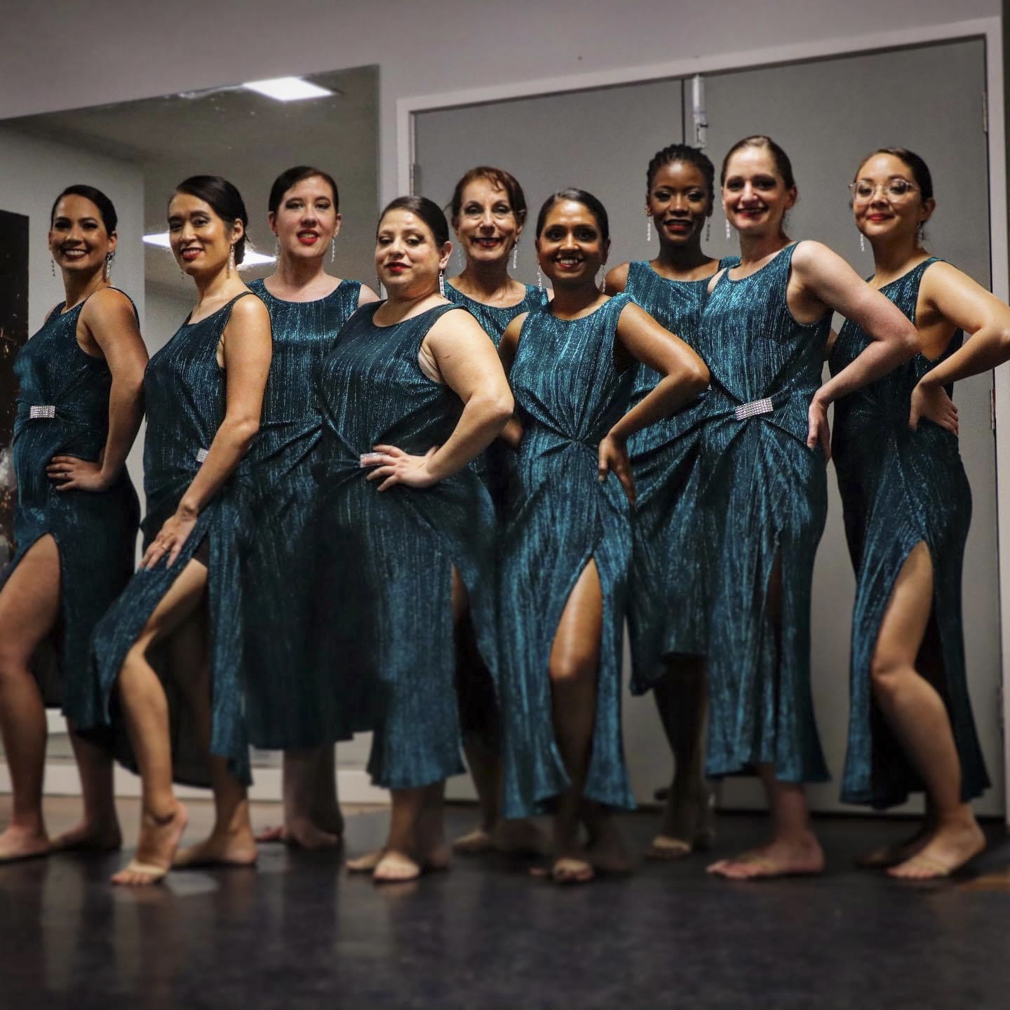 Dance group in elegant teal dresses backstage