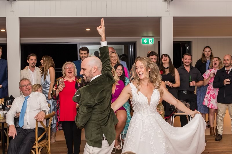 Wedding couple dancing to cheering guests at reception